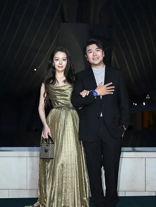 Gina Alice mengenakan gaun sutra emas Dior Cruise 2025. Ia juga mengenakan tas dan sepatu Dior. [Dior]