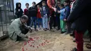 Pemilik kebun binatang Fathi Jumaa menaburkan bunga di kuburan empat anak singa di kebun binatangnya di kamp pengungsi Rafah, Gaza (18/1). Empat anak singa tersebut tewas pada pagi hari jelang berlangsungnya badai musim dingin.  (AP Photo/Adel Hana)