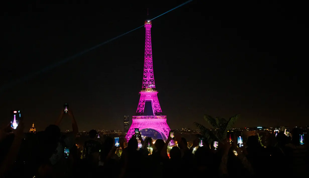 Foto yang diambil dari alun-alun Trocadero ini menunjukkan Menara Eiffel yang diterangi dengan warna merah muda di Paris pada tanggal 1 Oktober 2023. (Dimitar DILKOFF/AFP)