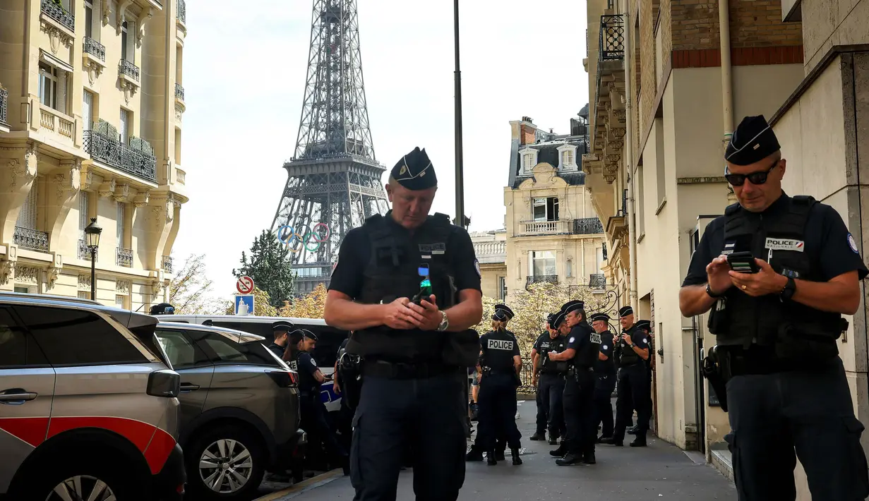 Petugas polisi berkumpul di sebuah jalan dekat Menara Eiffel jelang malam upacara pembukaan Paralimpiade Paris 2024, Selasa, 27 Agustus 2024 di Paris. (AP Photo/Thomas Padilla)