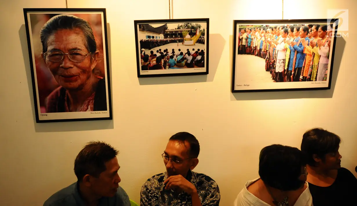 Pengunjung berbincang di depan deretan foto yang dipamerkan saat Peluncuran Buku Danau Toba dan Mangongkal Holi di Jakarta, Kamis (24/8). Pameran foto menampilkan kehidupan masyarakat dan budaya Batak. (LIputan6.com/Helmi Fithriansyah)