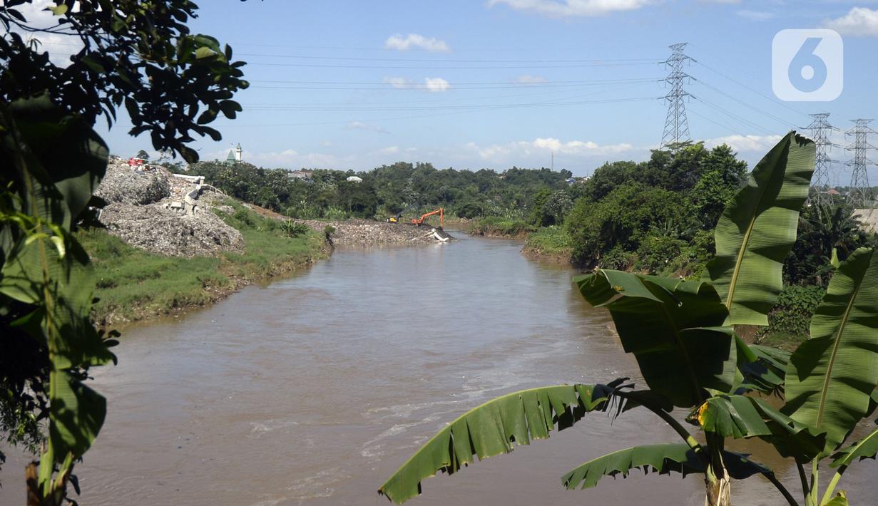 Pekerja menggunakan alat berat mengeruk sampah yang longsor di TPA Cipeucang, Serpong, Tangerang Selatan, Banten, Sebtu (23/5/2020). Turap penahan sampah TPA Cipeucang longsor pada 22 Mei 2020 dan hampir menutupi aliran Sungai Cisadane yang berada di sebelahnya. (merdeka.com/Dwi Narwoko