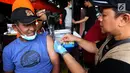 Petugas  mevaksin Td (Tetanus difteri) kepada warga korban gempa di kantor Dinkes Palu, Sulawesi Tengah, Minggu (7/10). Kemenkes dan Bio Farma memberikan 1000 vial vaksin Td untuk relawan dan masyarakat yang terdampak gempa. (Liputan6.com/Fery Pradolo)