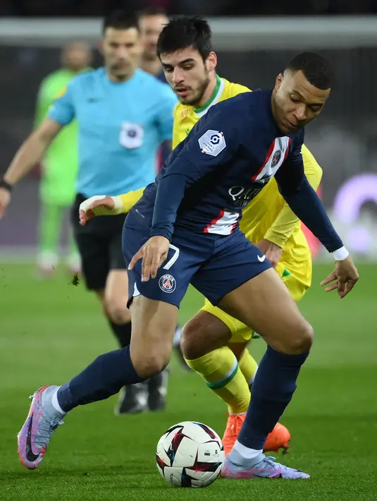 Penyerang Paris Saint-Germain atau PSG,Kylian Mbappe (depan) bersaing dengan bek Nantes Fabien Centonze pada pekan ke-26 Ligue 1 atau Liga Prancis 2022-2023 di Parc des Princes, Minggu (5/3/2023) dini hari WIB. Paris Saint-Germain memperpanjang catatan tak terkalahkan di kandang menjadi 35 laga di Ligue 1. (FRANCK FIFE / AFP)