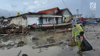 Warga membawa perkakas dari bangunan rumahnya yang rusak akibat terjangan tsunami di Kampung Sumur Pesisir, Pandeglang, Banten, Senin (24/12). Pascatsunami Selat Sunda, warga mulai kembali ke rumahnya masing-masing. (Merdeka.com/Arie Basuki)