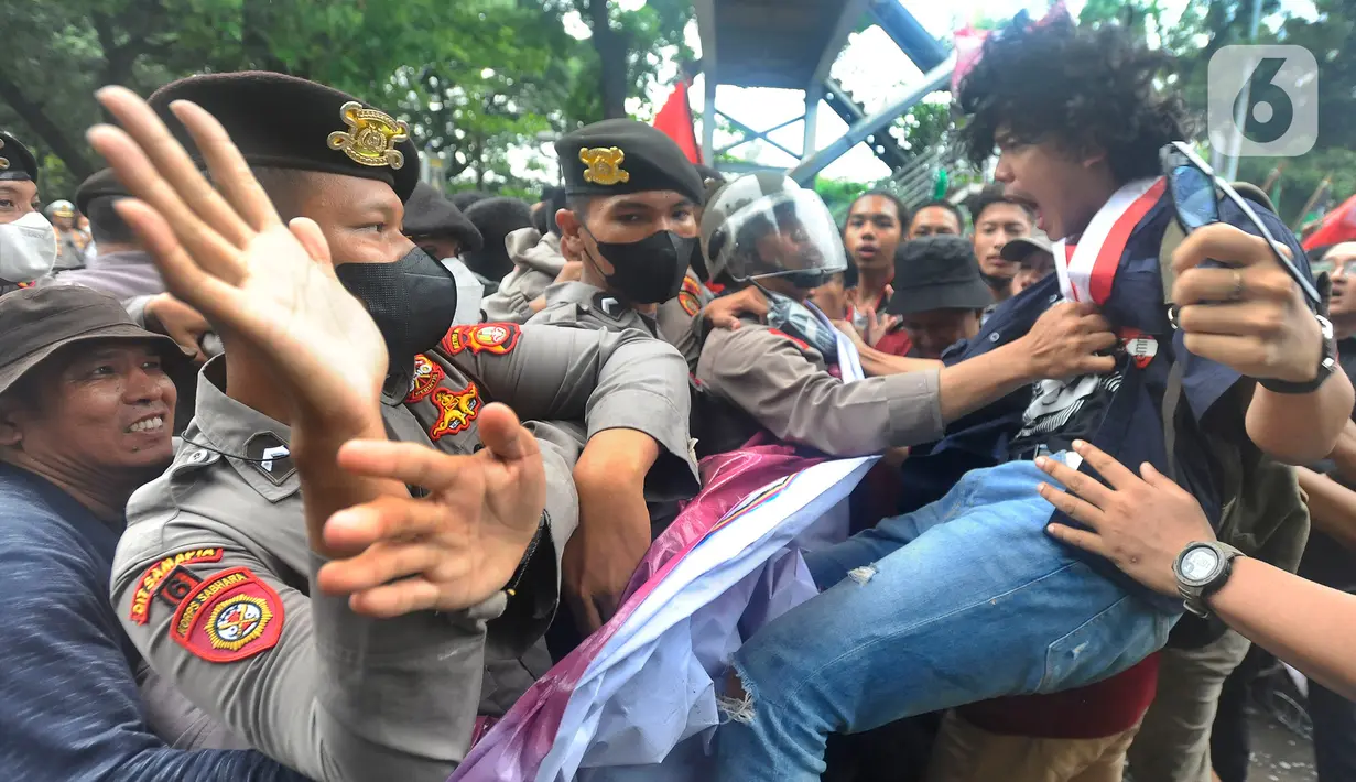 Petugas kepolisian saling dorong dengan mahasiswa yang demonstrasi menolak kenaikan harga BBM di kawasan Patung Kuda, Jakarta, Kamis (8/9/2022). Aksi saling dorong tersebut terjadi saat massa memaksa merangsek maju ke kawasan Istana Merdeka untuk menyampaikan aspirasi dan tuntutan langsung ke Presiden Joko Widodo. (merdeka.com/Arie Basuki)