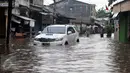 Sebuah mobil menerobos banjir di kawasan Pasar Buncit, Jakarta Selatan, Selasa (9/2/2016). Banjir menggenangi kawasan tersebut hingga setinggi 100 cm akibat luapan Kali Kemang. (Liputan6.com/Gempur M Surya)