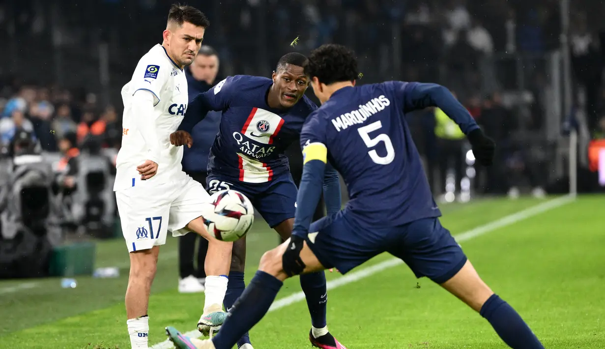 Penyerang Marseille Cengiz Under (Kiri) berebut bola dengan bek Paris Saint-Germain (PSG) Nuno Mendes dan Marquinhos dalam laga pekan ke-25 Liga Prancis 2022-2023, di Stadion Velodrome pada Senin (27/2/2023) dini hari WIB. PSG memegang kendali permainan setelah itu dan lebih banyak memainkan bola di tengah. (Photo by CHRISTOPHE SIMON / AFP)