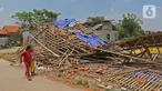 Anak-anak melintasi puing-puing bangunan rumah yang rusak diterjang angin puting beliung di Kaliabang Tengah, Kota Bekasi, Sabtu (24/10/2020). Menurut Badan Penanggulangan Bencana Daerah (BPBD) sebanyak 159 rumah terdampak puting beliung yang terjadi Jumat siang. (Liputan6.com/Herman Zakharia)
