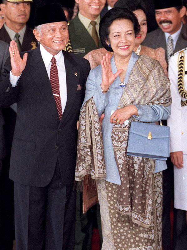 Presiden BJ Habibie didampingi istrinya Ainun Habibie melambaikan tangan kepada wartawan saat tiba di Gedung Parlemen, Jakarta, 21 Sptember 1999. Habibie bakal dikebumikan di Taman Makan Pahlawan Kalibata Jakarta Selatan pada Kamis, 12 September 2019. (AFP Photo/Oka Budhi)