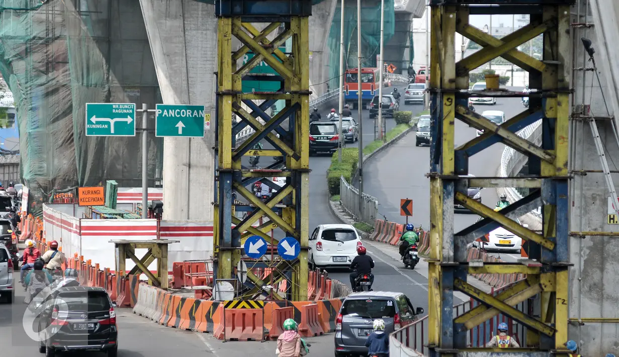 Kendaraan melintas di bawah proyek pembangunan jembatan layang di Jalan Kapten P. Tendean, Jakarta Selatan, (14/7). Aktivitas pembangunan jalan layang busway Tendean-Ciledug masih belum berjalan penuh pasca libur Lebaran. (Liputan6.com/Yoppy Renato)