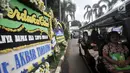 Pelayat melintasi karangan bunga duka cita untuk mendiang Eka Tjipta Widjaja di depan Rumah Duka Sentosa RSPAD Gatot Soebroto, Jakarta, Minggu (27/1). Eka Tjipta Widjaja meninggal dunia pada usia 98 tahun. (Merdeka.com/Iqbal Nugroho)
