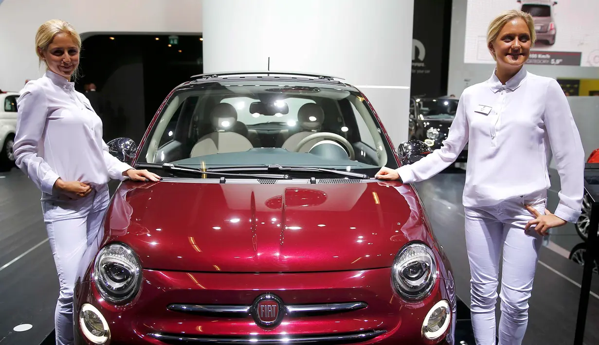 Dua model bergaya dengan salah satu mobil Fiat 500 saat Frankfurt Motor Show (IAA) 2015 di Frankfurt, Jerman (16/9/2015). Sejumlah merek kendaraan ternama ikut ambil bagian dalam pameran tersebut. (REUTERS/Kai Pfaffenbach)