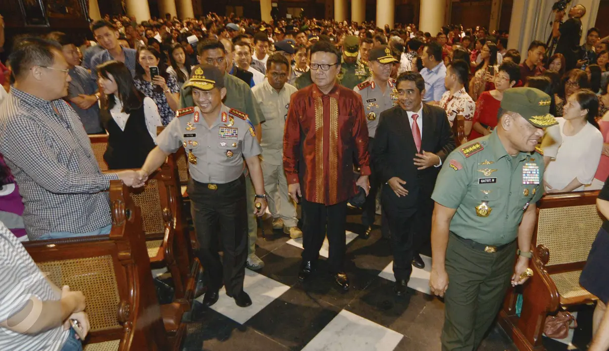 Kapolri Jendral Tito Karnavian bersalaman dengan salah satu jemaat saat meghadiri misa natal di Gereja katedral, Jakarta, Sabtu (24/12). Kedatangannya unutk mengecek keamanan dan mengucapkan natal secara langsung kegereja. (Liputan6.com/Helmi Afandi)