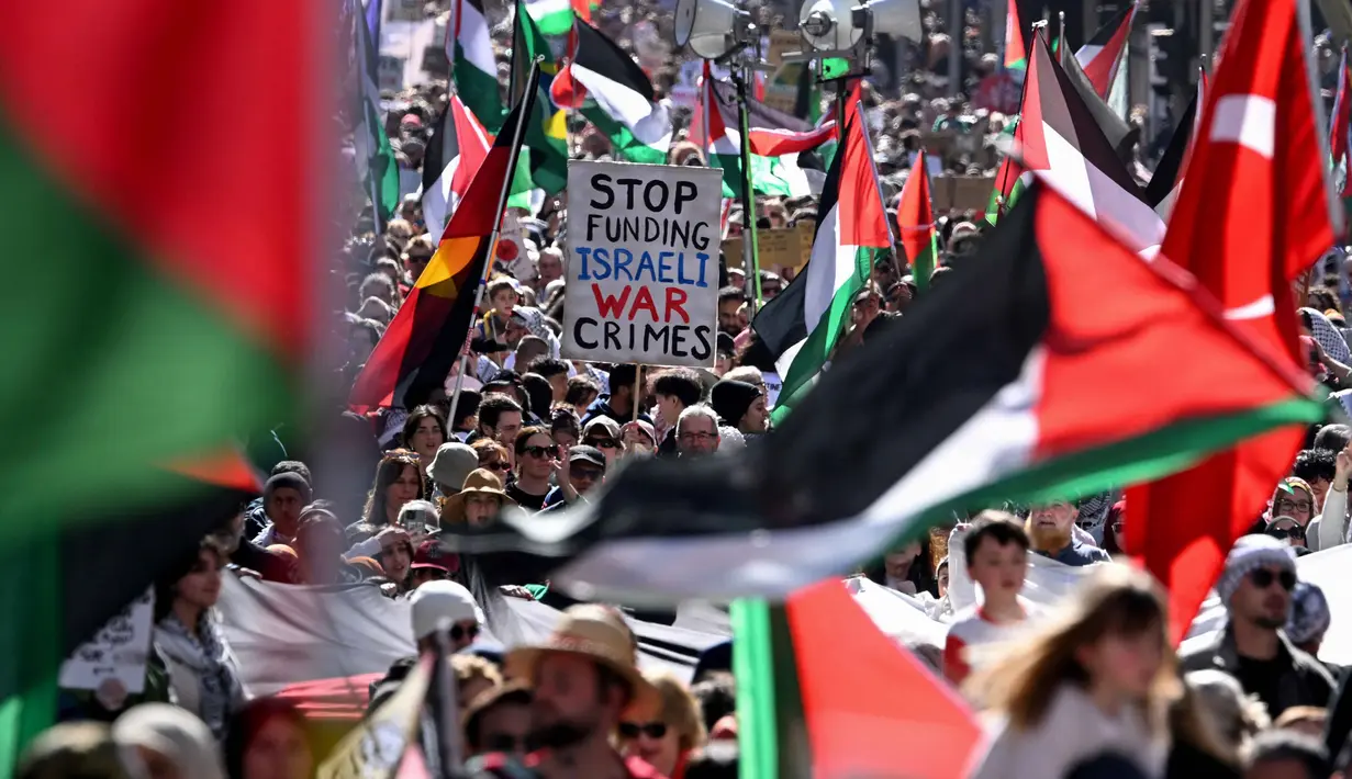 Sambil membentang spanduk dan pamflet, pengunjuk rasa mendesak pemberian sanksi internasional kepada Israel. (William WEST/AFP)