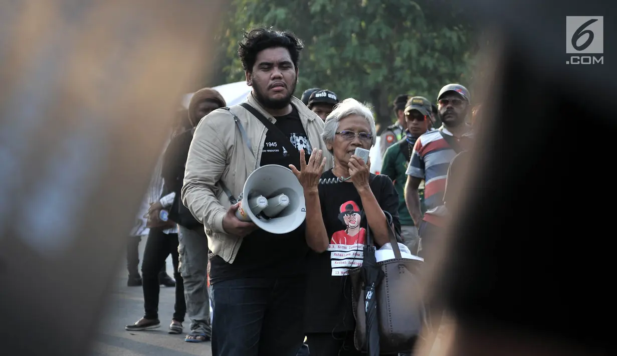 Seorang ibu yang tergabung dalam Jaringan Solidaritas Korban untuk Keadilan (JSKK) berorasi saat menggelar Aksi Kamisan di depan Istana Negara, Jakarta, Kamis (2/8). Aksi ini merupakan yang ke-547. (Merdeka.com/Iqbal Nugroho)