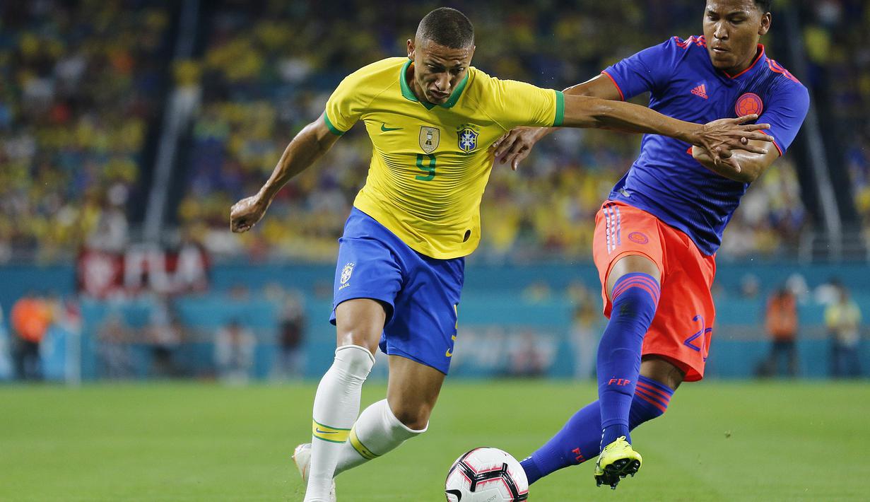 Gelandang Brasil, Richarlison, berusaha melewati bek Kolombia, Roger Martinez, pada laga persahabatan di Stadion Hard Rock, Florida, Jumat (6/9). Kedua negara bermain imbang 2-2. (AFP/Rhona Wise)