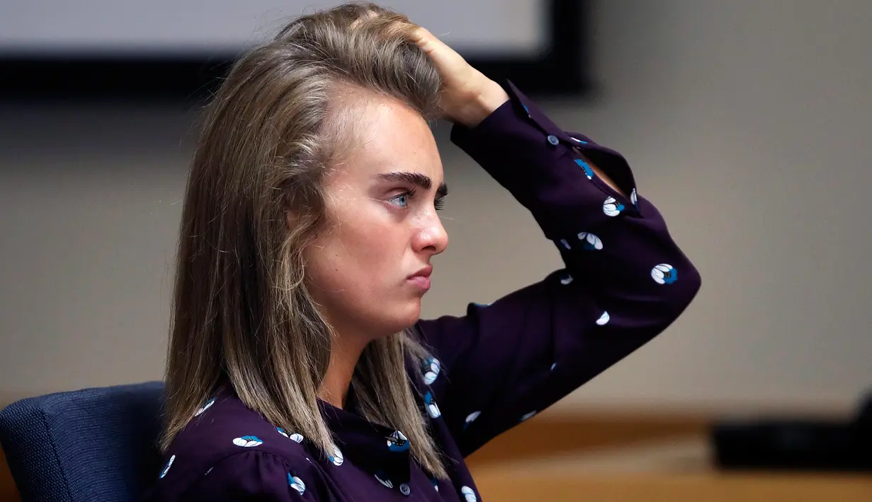 Terdakwa Michelle Carter merapihkan rambutnya saat menghadiri sidang di Pengadilan Negeri Taunton di Taunton, Mass, (8/6). Wanita berusia 20 tahun ini dituduh melakukan pembunuhan pada bulan Juli 2014. (AP Photo/Charles Krupa, Pool)