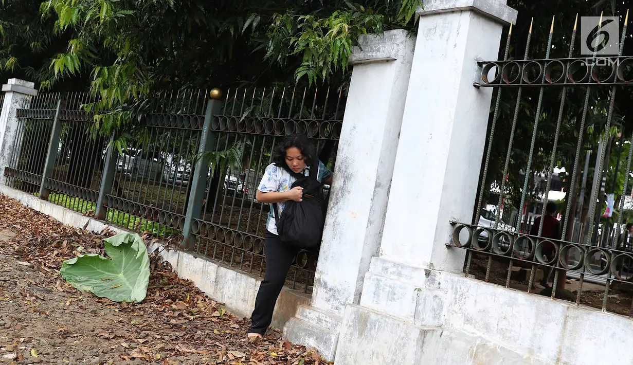 Warga menerobos pagar untuk menyeberangi rel kereta api di kawasan Lenteng Agung, Jakarta, Selasa (19/3). Tidak adanya JPO menyebabkan warga harus menerobos pagar besi, meskipun perilaku tersebut berbahaya bagi keselamatan.(Liputan6.com/Immanuel Antonius)