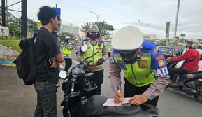 Satlantas Polres Metro Depok memberikan penindakan kepada pelanggar pengguna jalan raya pada Operasi Zebra Jaya 2025 di Jalan Raya Margonda, Depok. (Liputan6.com/Dicky Agung Prihanto)