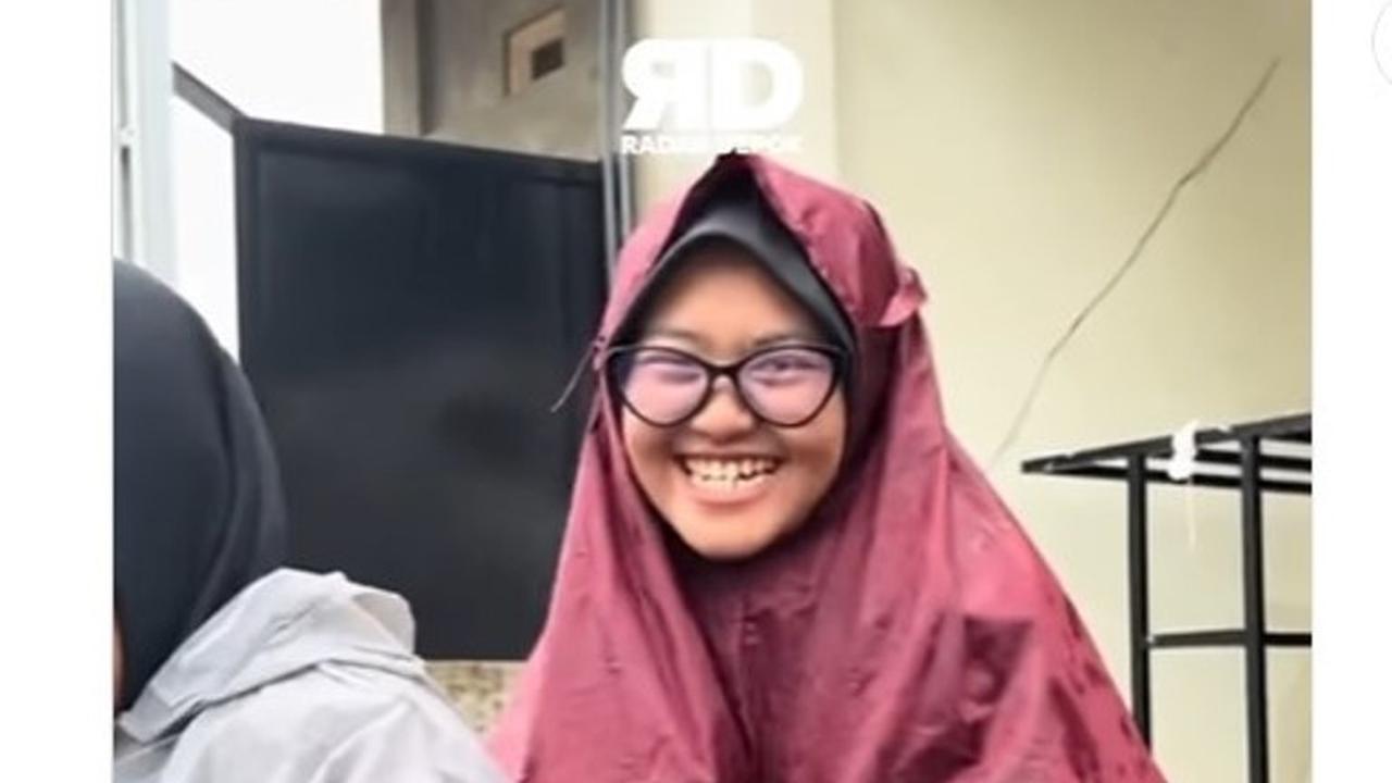 Seorrang Wanita Niat Tampil Modis dengan Jas Hujan, Malah Disangka Pakai Mukena Kekecilan.  foto: (dok.Instagram @radar.depok/https://www.instagram.com/radar.depok/reel/DAS8TfmSyJj/Henry)