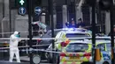 Petugas forensik meneliti lokasi serangan teror Inggris di dekat gedung parlemen di London, Rabu (22/3). Sedikitnya lima orang tewas dalam serangan teror di Jembatan Westminster dan di dekat Gedung Parlemen itu. (Yui Mok/PA via AP)