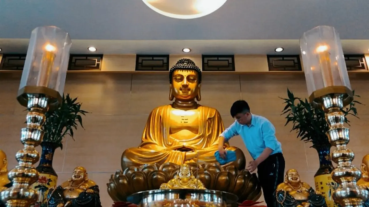 Seorang pengurus vihara di Pekanbaru membersihkan patung budha menyambut tahun baru Imlek.
