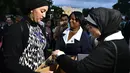 Seorang wanita menawarkan kurma untuk berbuka puasa Ramadan di Lafayette Square, Washington DC (6/6). Acara ini juga bertepatan dengan buka puasa bersama yang diikuti Presiden AS, Donald Trump di Gedung Putih. (AFP/Mandel Ngan)