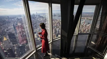 Seorang wanita menikmati pemandangan Kota Manhattan dari ruangan observatorium di lantai 102 Gedung Empire State yang baru direnovasi di New York (10/10/2019). Dibuka untuk umum pada 12 Oktober, ruang observatorium ini berjarak 1.250 kaki di atas permukaan jalan. (AFP Photo/Drew Angerer)