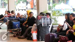 Sejumlah calon penumpang duduk menanti waktu masuk ke dalam Bandara Halim Perdanakusuma Jakarta, Senin (4/7). H-2 jelang Idul Fitri 1437 H, ribuan calon penumpang diberangkatkan dari Bandara Halim Perdanakusuma. (Liputan6.com/Helmi Fithriansyah)