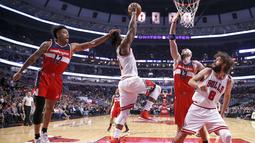 Pemain Washington Wizards, Kelly Oubre Jr. (kiri) melanggar pemain Chicago Bulls (dua kiri) Jimmy Butler  pada laga NBA basketball game di United Center, Chicago, (21/12/2016).  Wizards menang 107-97. (AP/Charles Rex Arbogast)