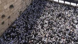 Pria-pria Yahudi berdoa dengan mengenakan selendang saat mereka berpartisipasi dalam pemberkatan selama hari raya Yahudi Sukkot di Tembok Barat di bawah masjid Kubah Batu di Kota Tua Yerusalem, Rabu, 12 Oktober 2022. (AP Photo/Tsafrir Abayov)