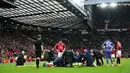 Petugas medis menangani pemain Manchester United, Lisandro Martinez yang tengah cedera dalam laga lanjutan Liga Inggris 2024/2025 melawan Crystal Palace di Old Trafford, Manchester, Inggris, Minggu (02/02/2025). (AFP/Paul Ellis)