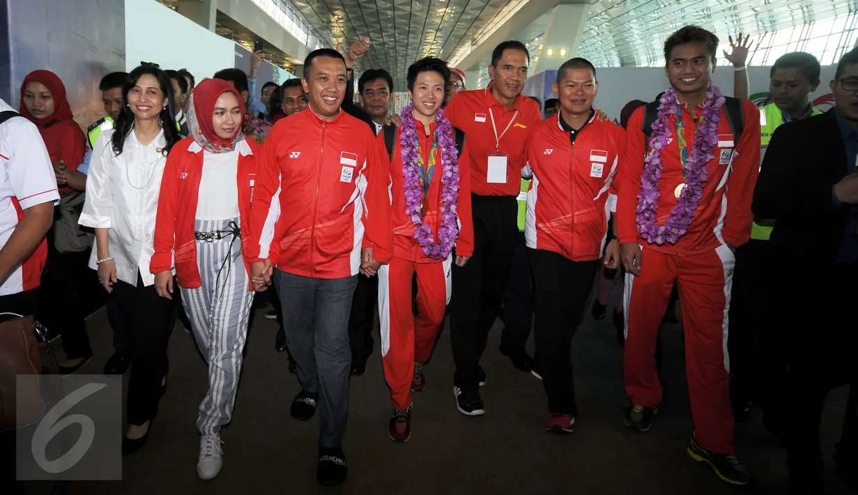 Ketua Umum PBSI, Gita Wirjawan (keempat kanan) berjalan bersama Tontowi Ahmad dan Lilyana Natsir di Bandara Soetta, Banten, Selasa (23/8/2016). Tontowi Ahmad/Lilyana Natsir berhasil meraih emas olimpiade Rio 2016. (Liputan6.com/HelmiFithriansyah)