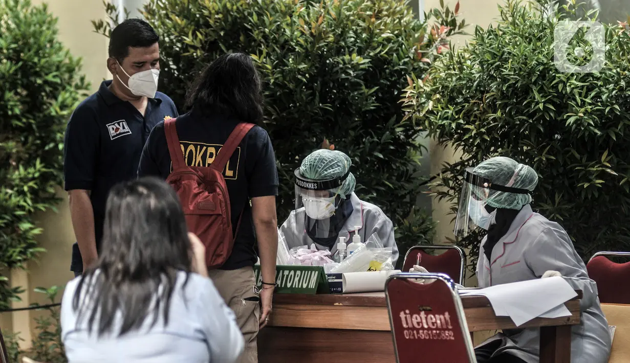 Tenaga kesehatan mendata keluarga korban pesawat Sriwijaya Air SJ 182 yang akan tes usap COVID-19 sebelum memberikan data di Posko Ante Mortem DVI, RS Polri, Jakarta, Minggu (10/1/2020). Keluarga korban mendatangi posko ante mortem pascajatuhnya Sriwijaya Air SJ 182. (merdeka.com/Iqbal S. Nugroho)
