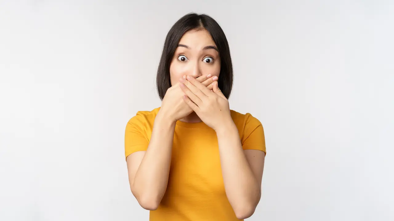 Seorang perempuan menutup mulutnya dengan kedua tangan (Foto Dok: Freepik/benzoix)