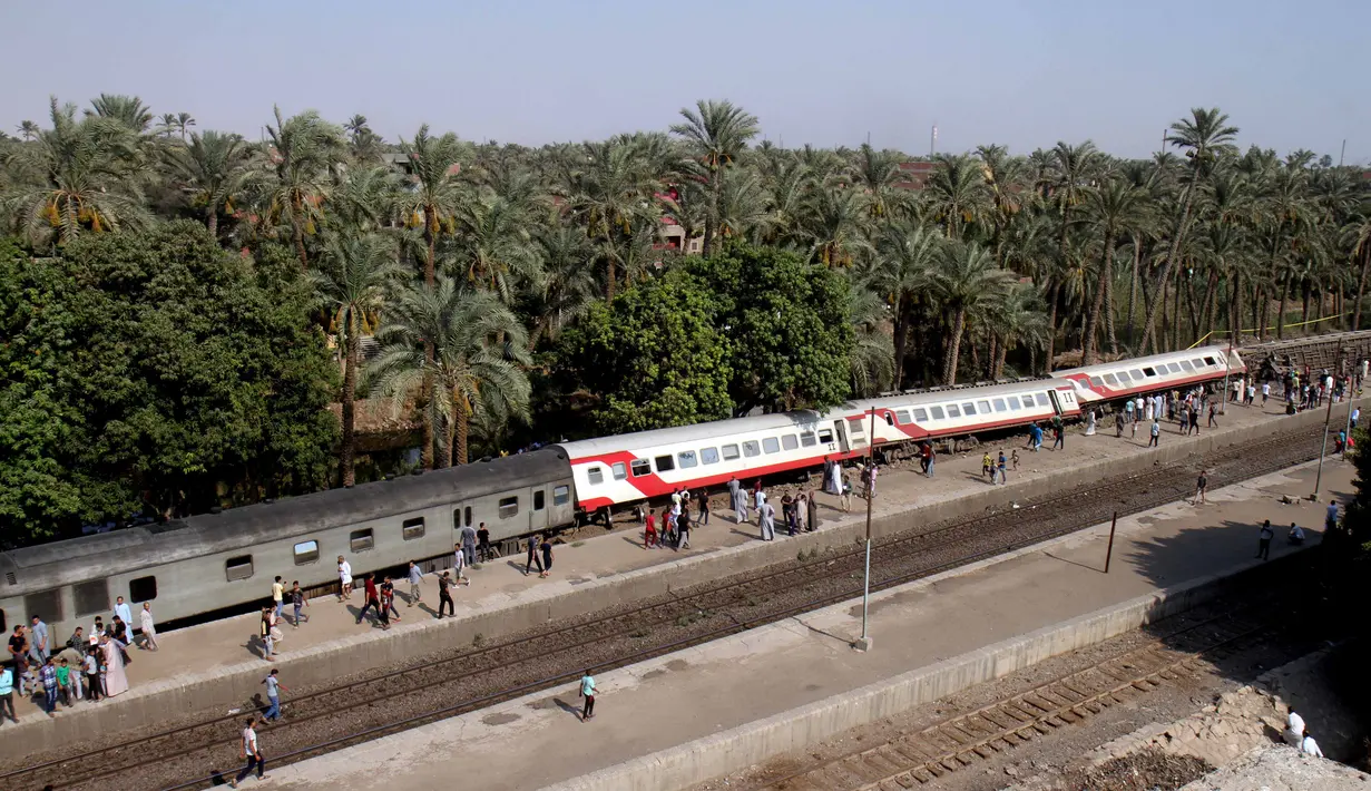 Sejumlah gerbong kereta penumpang keluar jalur usai tergelincir saat melintasi jalur di daerah al-Badrasheen, Giza, Mesir, (13/7). Dalam kejadian tersebut, tidak ada korban jiwa dan sekitar 55 penumpang terluka. (AFP Photo/Stringer)
