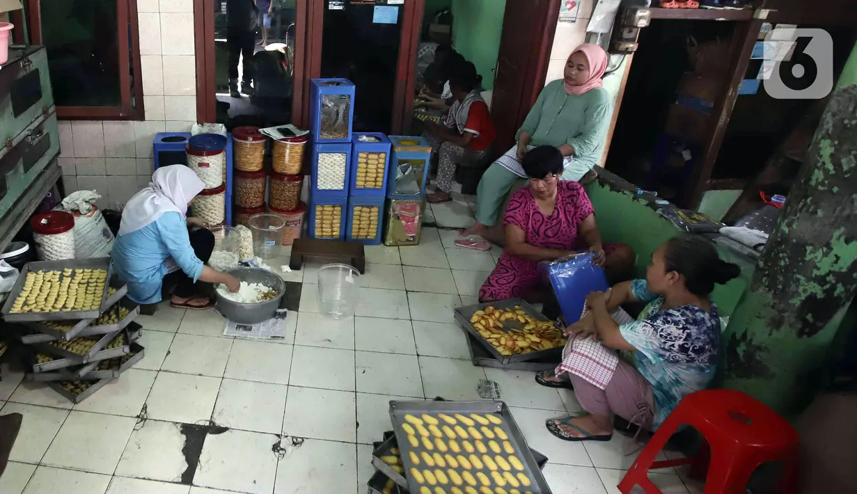 Para pekerja menyelesaikan pembuatan kue kering skala rumah tangga Pusaka Kwitang di kawasan Senen, Jakarta, Rabu (13/4/2022). Harga jual kue kering Ramadhan naik dari Rp 70.000 per kilogram pada tahun lalu menjadi Rp 80.000 - Rp 85.000 per kilogram. (Liputan6.com/Herman Zakharia)