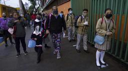 Para siswa mengantre untuk masuk sekolah umum saat tahun ajaran baru dimulai selama pandemi COVID-19 di Mexico City, Meksiko, Senin (30/8/2021). Jutaan anak Meksiko mulai menjalani sekolah tatap muka. (AP Photo/Fernando Llano)