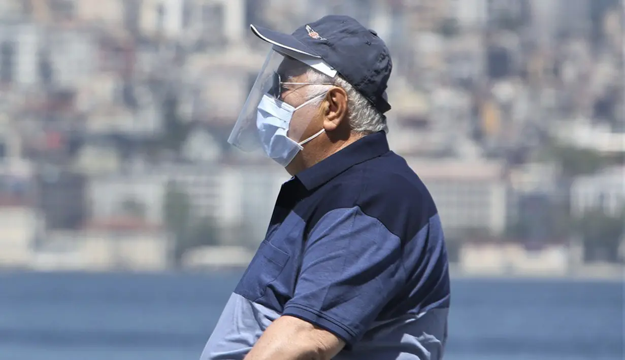 Seorang lansia mengenakan masker dan pelindung wajah saat jalan-jalan di Istanbul, Turki, Minggu (10/5/2020). Setelah melonggarkan lockdown terkait virus corona COVID-19, Turki mengizinkan para lansia berusia 65 tahun ke atas untuk keluar rumah.