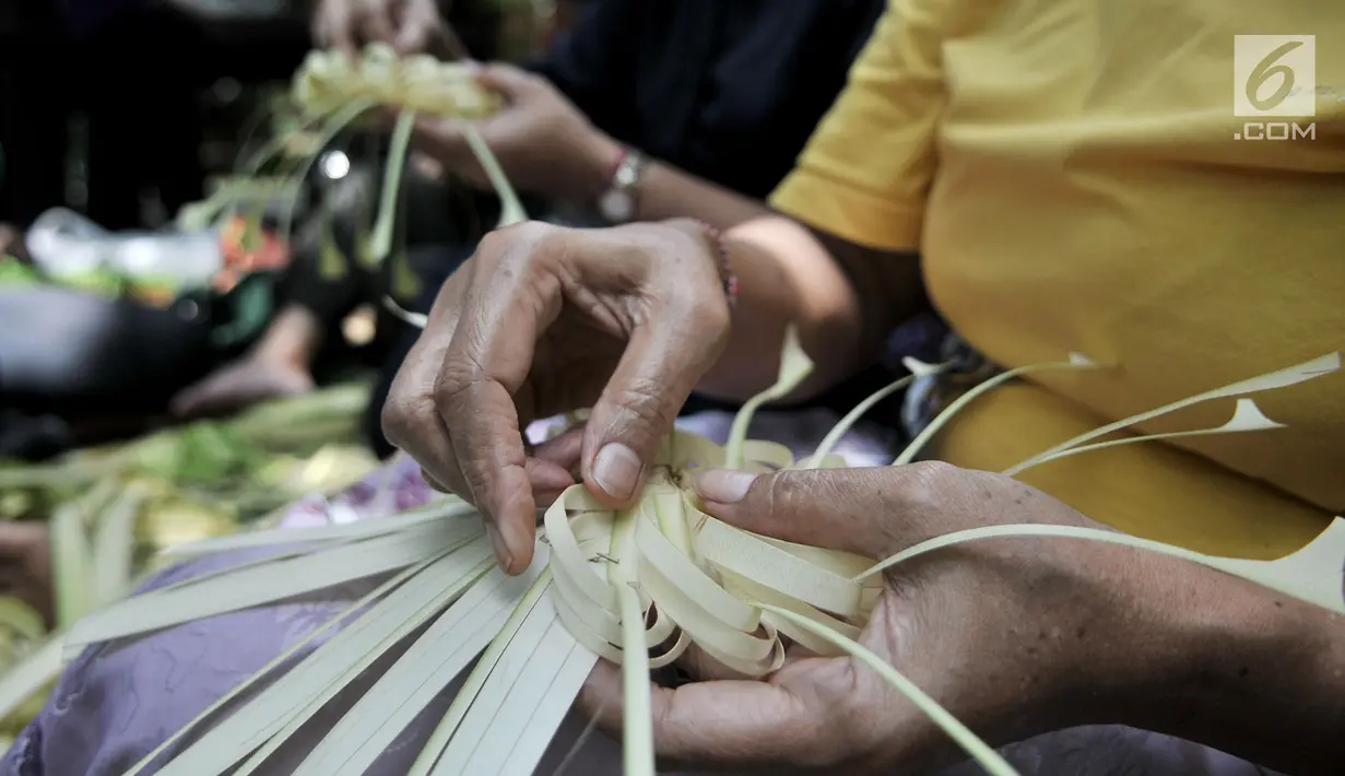 Umat Hindu bersama-sama membuat sajen (Ngayah) di Pura Aditya Jaya, Jakarta, Senin (4/3). Ngayah merupakan tradisi yang dilakukan gotong-royong oleh kaum perempuan Hindu dalam membuat sajen untuk persiapan sembahyang  Nyepi. (merdeka.com/Iqbal S. Nugroho)