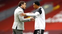 Pelatih Fulham, Scott Parker, melakukan selebrasi bersama Kenny Tete usai berhasil menaklukkan Liverpool pada laga Liga Inggris di Stadion Anfield, Minggu (7/3/2021). Fulham menang dengan skor 0-1. (Phil Noble/Pool via AP)
