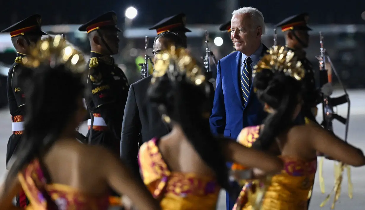 Presiden Amerika Serikat (AS) Joe Biden disambut oleh tarian khas Bali saat turun dari pesawat kepresidenan AS, Air Force One setibanya di Bandara I Gusti Ngurah Rai Bali, Minggu (13/11/2022). Kehadiran Joe Biden untuk menghadiri Konferensi Tingkat Tinggi (KTT) G20 di Bali yang akan digelar pada 15-16 November 2022. (SAUL LOEB / AFP)