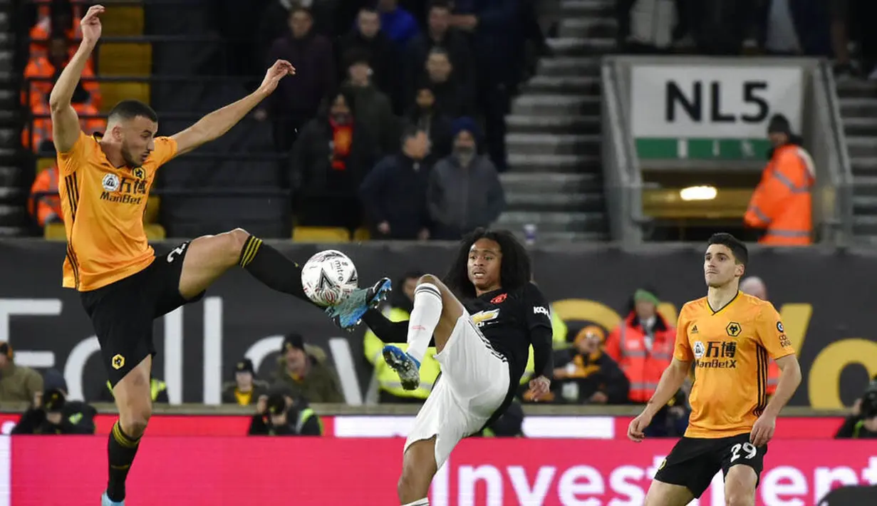 Pemain Manchester United, Tahith Chong, berebut bola dengan pemain Wolverhampton Wanderers, Romain Saiss, pada laga Piala FA di Stadion Molineux, Sabtu (4/1/2020). Kedua tim bermain imbang 0-0. (AP/Rui Vieira)