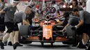 Kesibukan tim mekanik McLaren saat melihat kondisi mobil pebalap Stoffel Vandoorne di pit lane pada sesi latihan bebas F1 GP Singapura, Marina Bay City Circuit, (15/9/2017). (AP/Wong Maye-E)