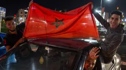 Warga Maroko konvoi merayakan keberhasilan negaranya lolos ke Piala Dunia 2018 di Rabat, Sabtu (11/11/2017). Maroko lolos setelah mengalahkan Pantai Gading 2-0 pada laga penentu. (AFP/Fadel Senna)