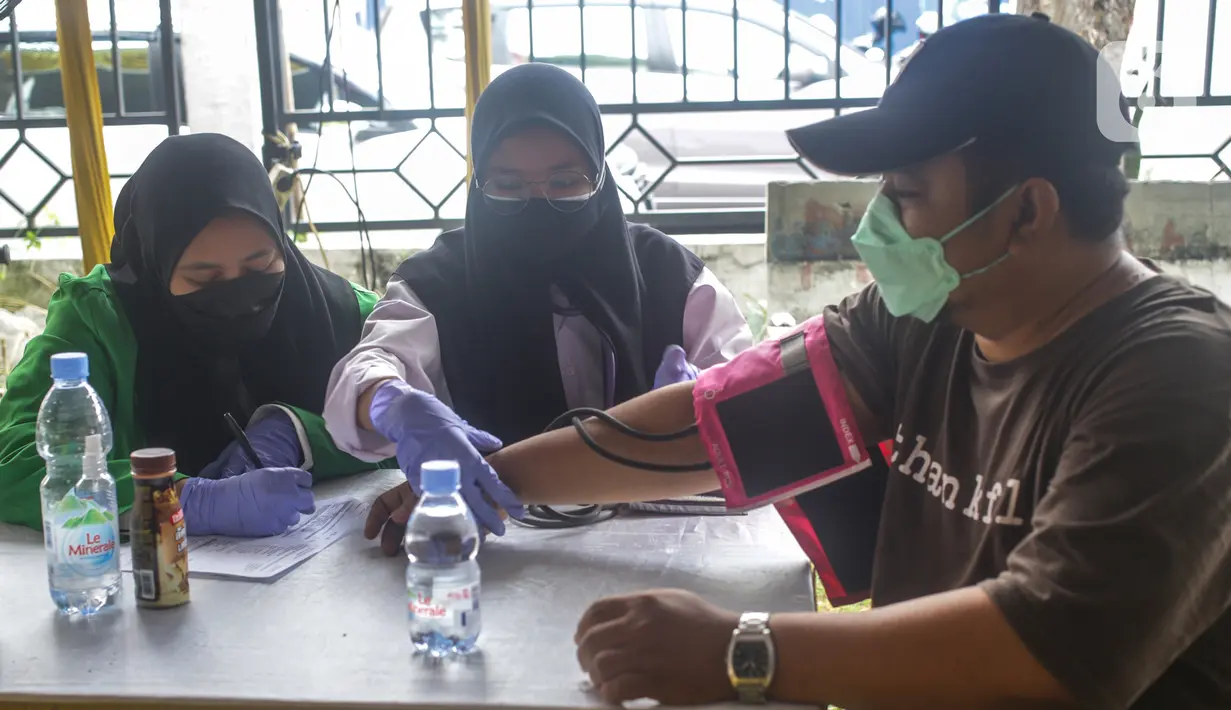 Petugas medis mengecek kesehatan warga sebelum mengikuti program vaksinasi massal Covid-19 di PMI Kota Bekasi, Jawa Barat, Sabtu (21/08/2021). Vaksin yang digunakan dalam vaksinasi massal tersebut yakni vaksin Astrazeneca. (Liputan6.com/Herman Zakharia)