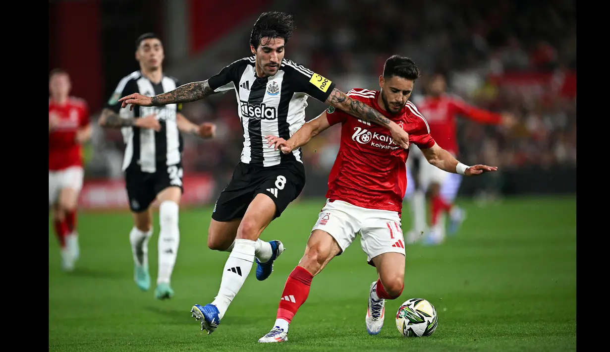 Pemain Newcastle, Sandro Tonali (kiri) berebut bola dengan pemain Nottingham Forest, Alex Moreno saat laga Carabao Cup 2024/2025 di City Ground, Nottingham, Inggris, Kamis (29/08/2024) WIB. (AFP/Paul Ellis)