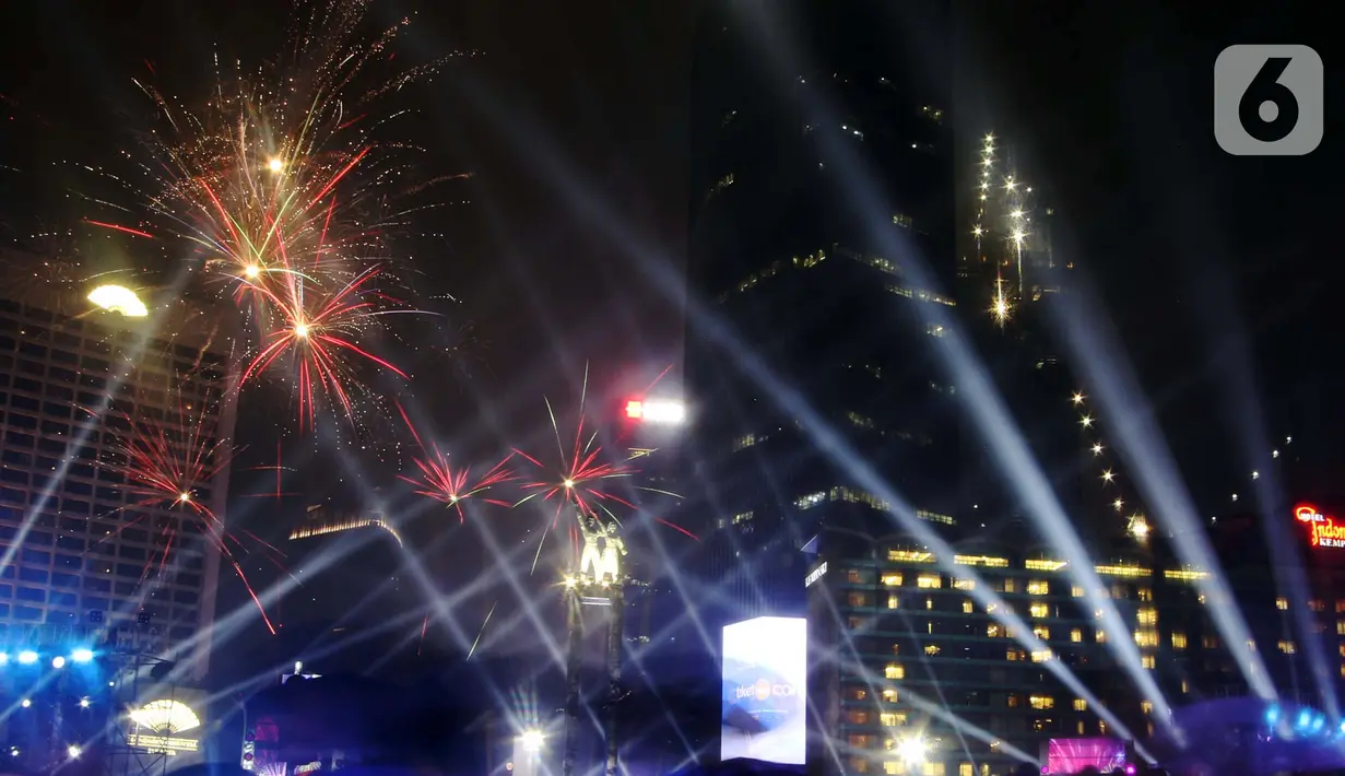 Nyala kembang api memeriahkan malam pergantian tahun di Bundaran Hotel Indonesia, Jakarta, Selasa (31/12/2019). Meski Jakarta diguyur hujan sejak Selasa (31/12) sore, warga tetap antusias melewati malam pergantian tahun 2019 menuju 2020 di kawasan Bundaran HI Jakarta. (Liputan6.com/Angga Yuniar)