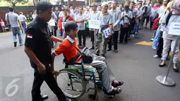 Seorang penumpang disabilitas pada acara gelar mudik bersama Bank Syariah Mandiri (BSM) di Jakarta, Sabtu (2/7). Sebanyak 1200 pemudik diberangkatkan dengan 25 bus dan satu unit mobil akses untuk disabilitas (14 Orang). (Liputan6.com/Faizal Fanani)